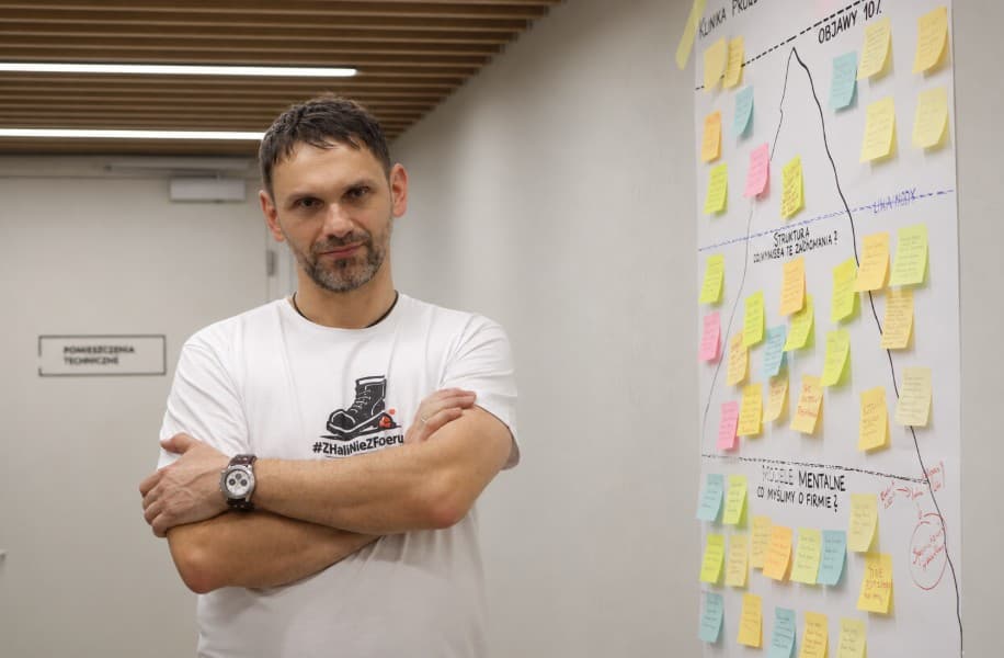 Krzysztof Skrzypczak przy ścianie z analizą objawów, struktury i modeli mentalnych firmy